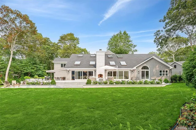 a front view of a house with a garden and trees