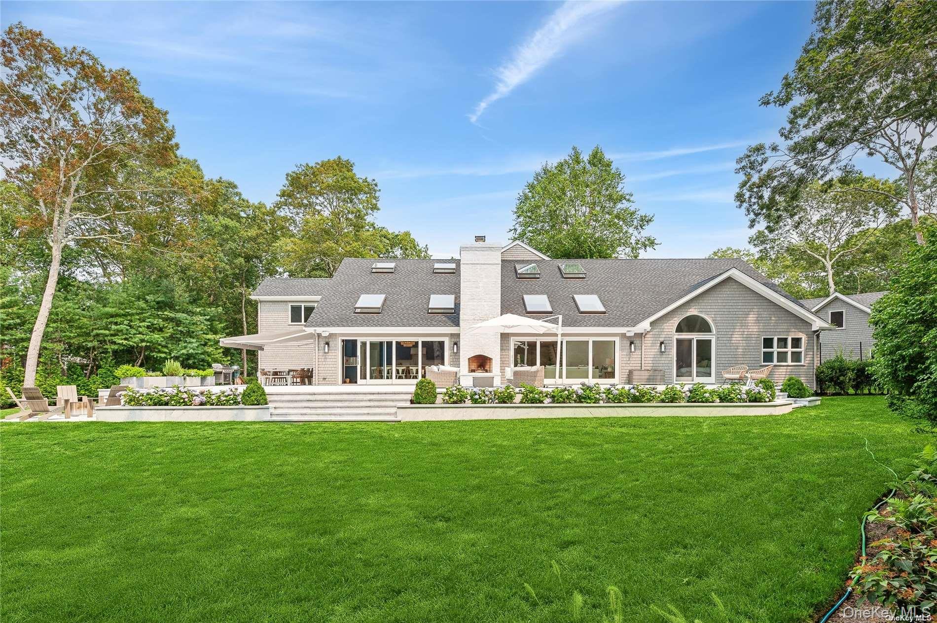 28 Old Meeting House Road Quogue, NY 11959 - Photo 28 of 34 a front view of a house with a garden and trees