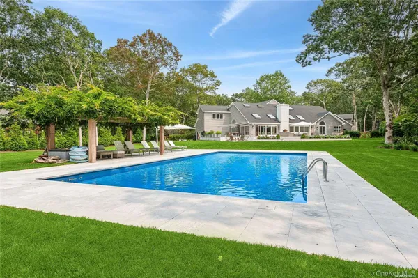 a view of an house with swimming pool and yard