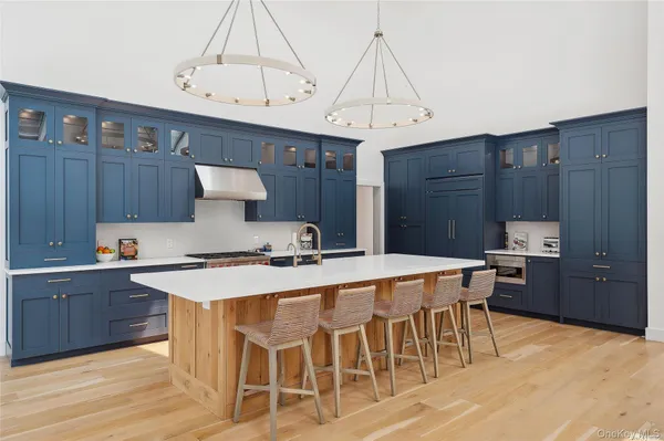 a kitchen with stainless steel appliances a table chairs and a refrigerator