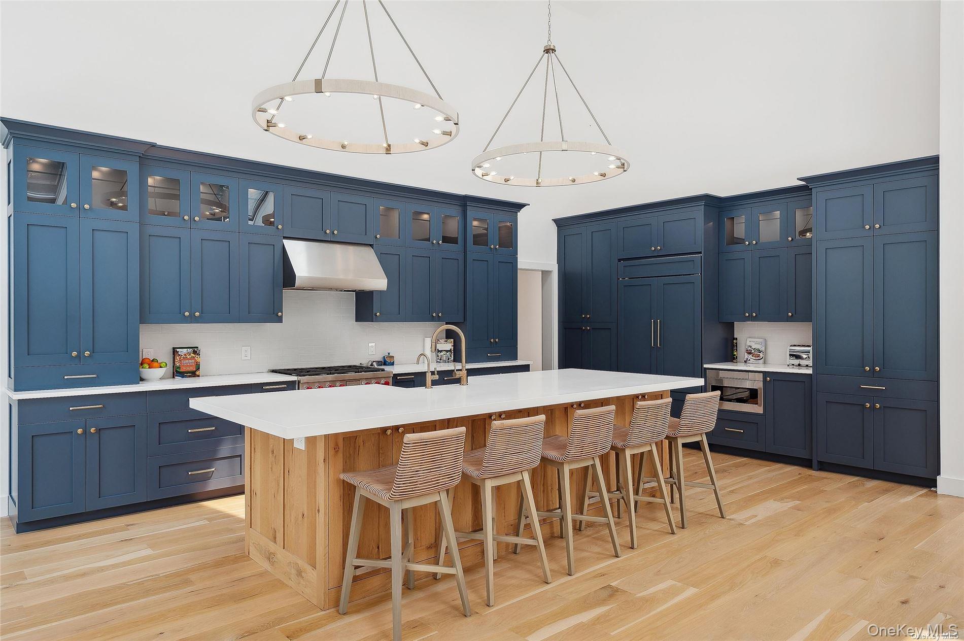 28 Old Meeting House Road Quogue, NY 11959 - Photo 9 of 34 a kitchen with stainless steel appliances a table chairs and a refrigerator