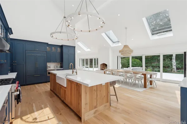 a large room with kitchen island a sink a counter space and stainless steel appliances