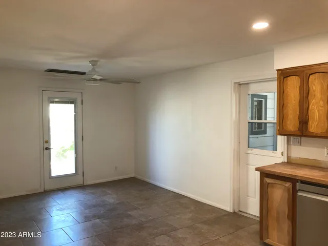 an empty room with windows and cabinet
