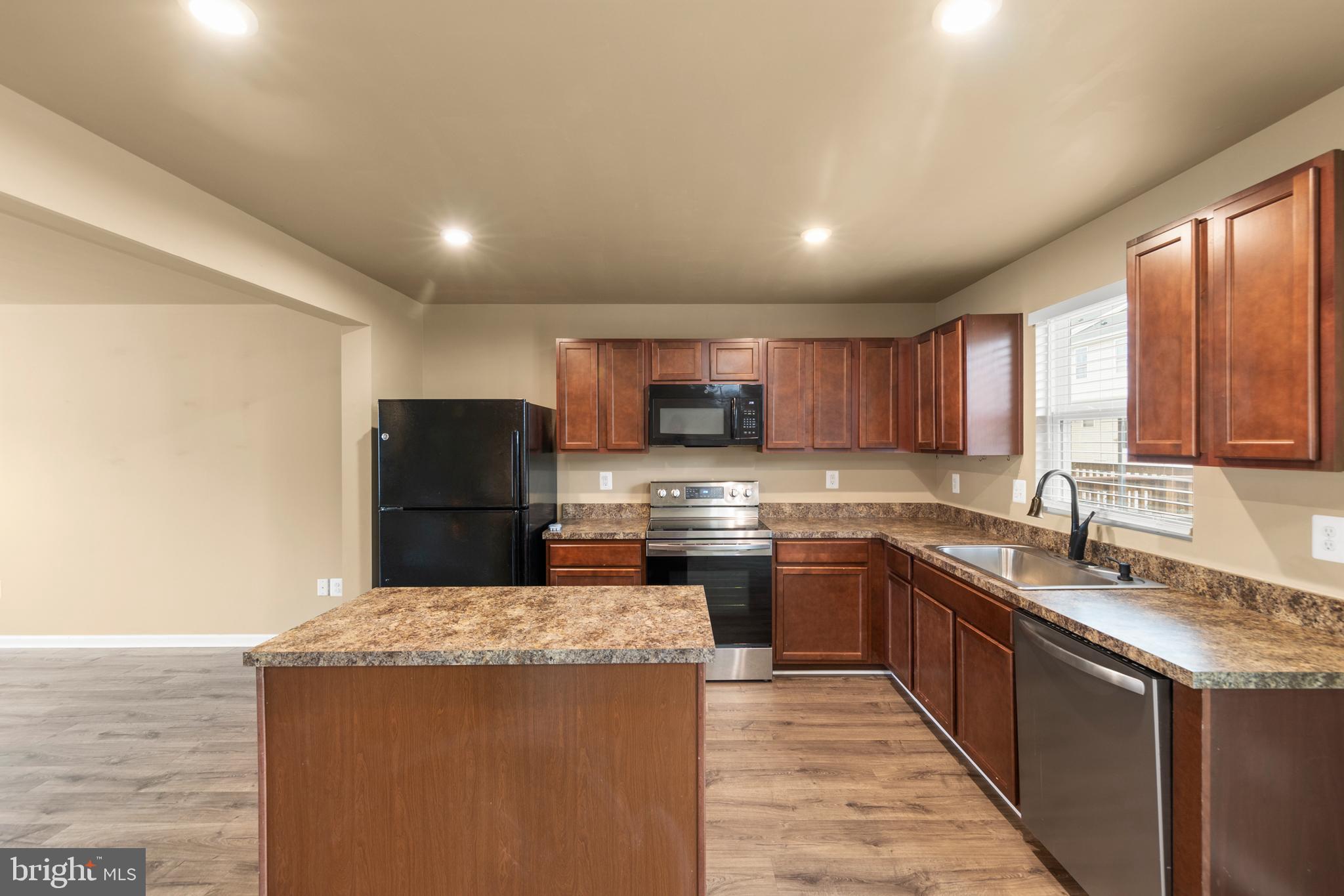 113 Reign Way Winchester, VA 22603 - Photo 5 of 35 a kitchen with stainless steel appliances granite countertop a sink stove and refrigerator