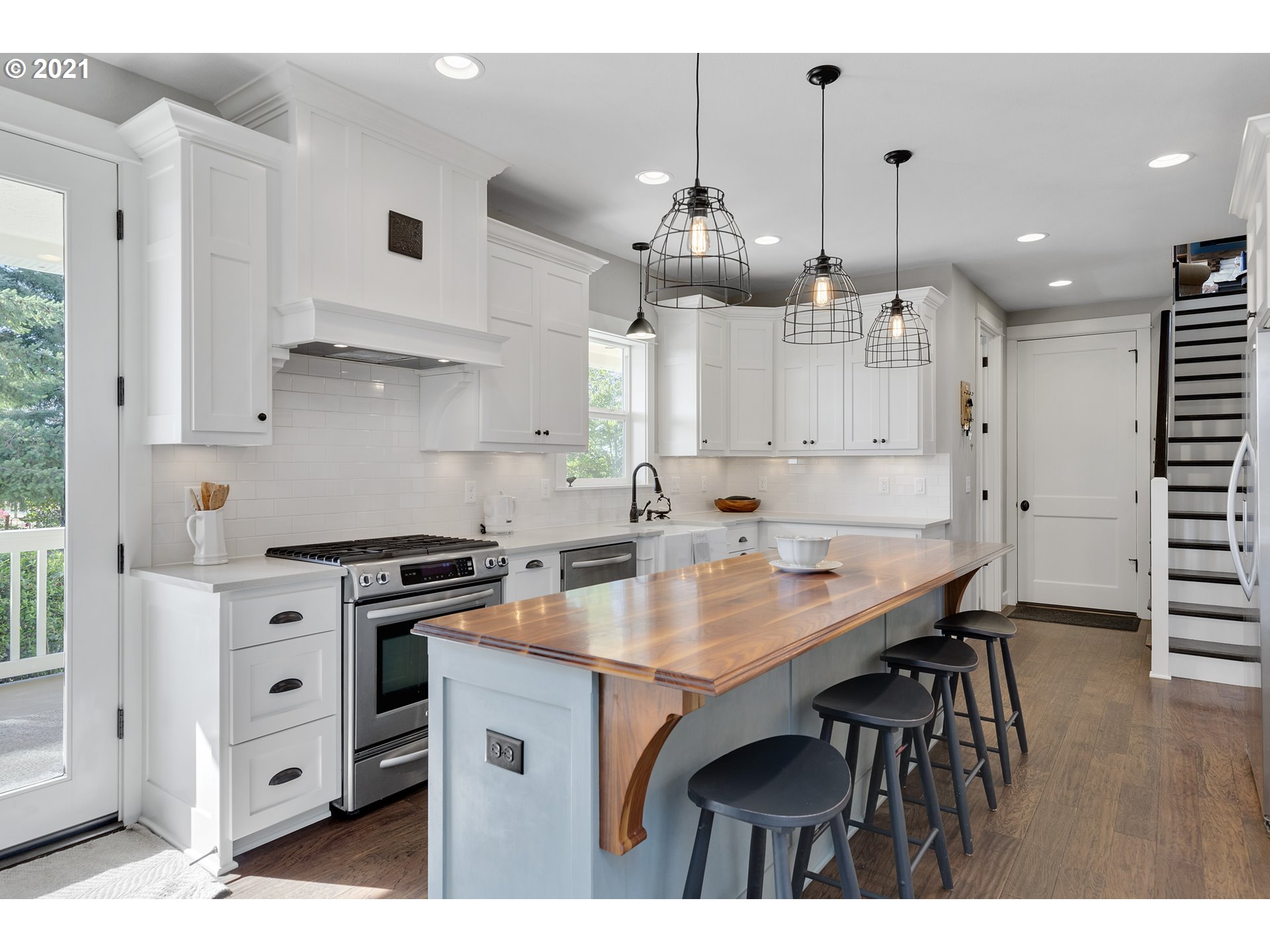 32991 South Kropf Road Molalla, OR 97038 - Photo 11 of 32 a kitchen with stainless steel appliances a table chairs wooden floors and white cabinets