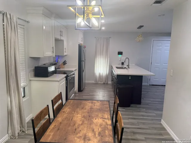 a kitchen with refrigerator and cabinets