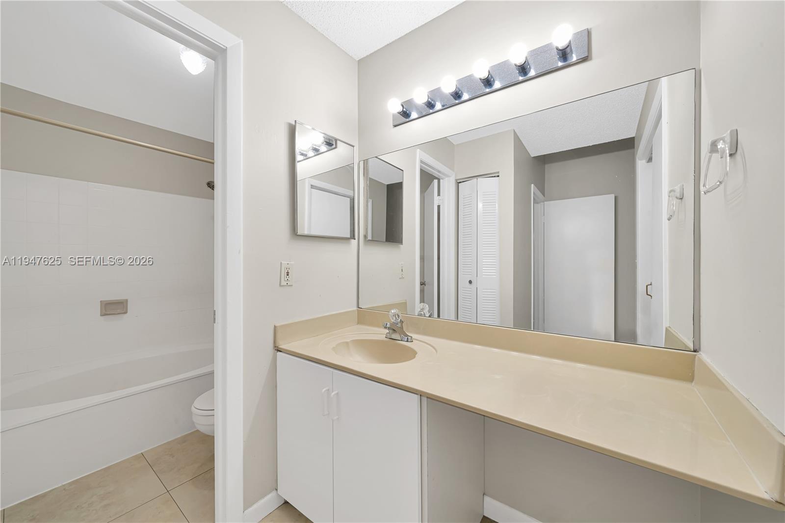 14325 Southwest 57th Lane, Unit 66 Miami, FL 33183 - Photo 14 of 22 a bathroom with a sink vanity tub and a mirror