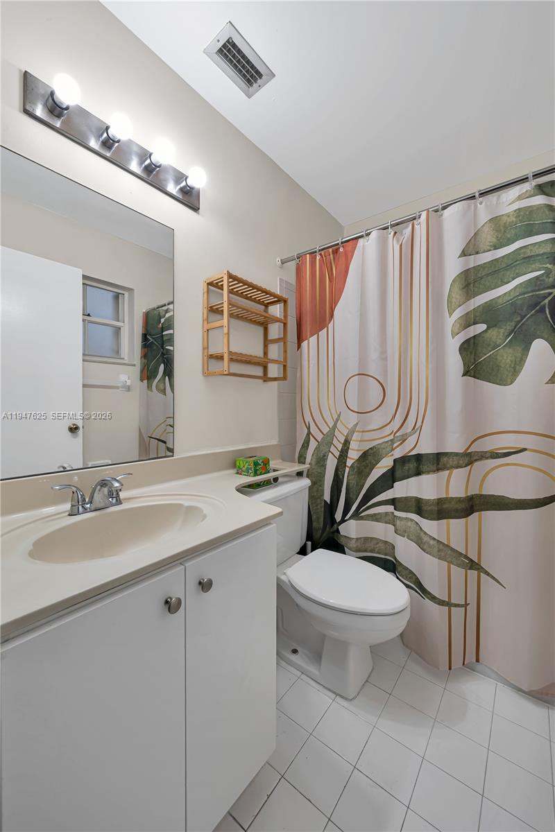 14325 Southwest 57th Lane, Unit 66 Miami, FL 33183 - Photo 18 of 22 a bathroom with a toilet a sink and mirror