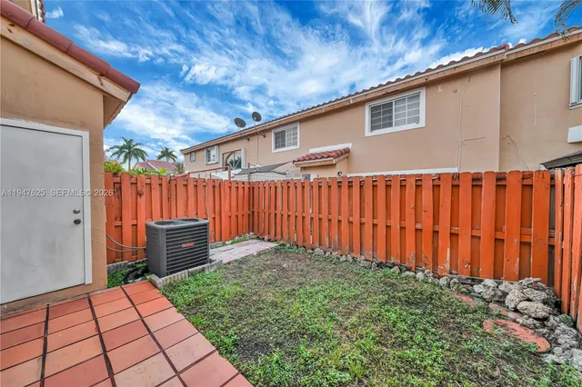 a backyard of a house with table and chairs