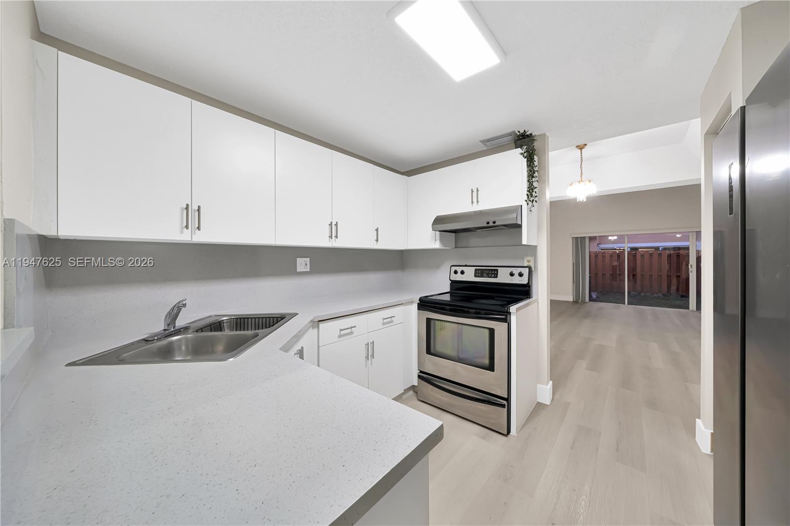 14325 Southwest 57th Lane, Unit 66 Miami, FL 33183 - Photo 7 of 22 a kitchen with granite countertop a sink and a stove top oven