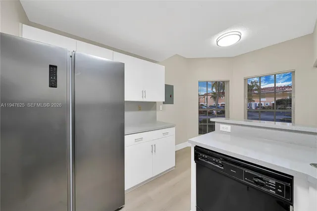a kitchen with a refrigerator and a stove top oven