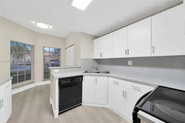 a kitchen with granite countertop white cabinets and white appliances