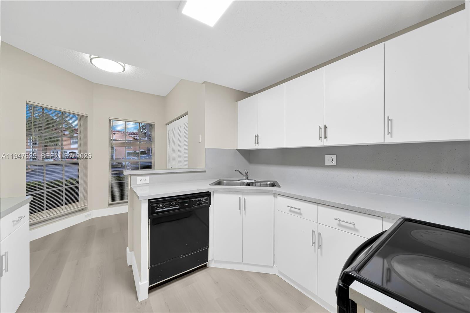 14325 Southwest 57th Lane, Unit 66 Miami, FL 33183 - Photo 9 of 22 a kitchen with granite countertop white cabinets and white appliances