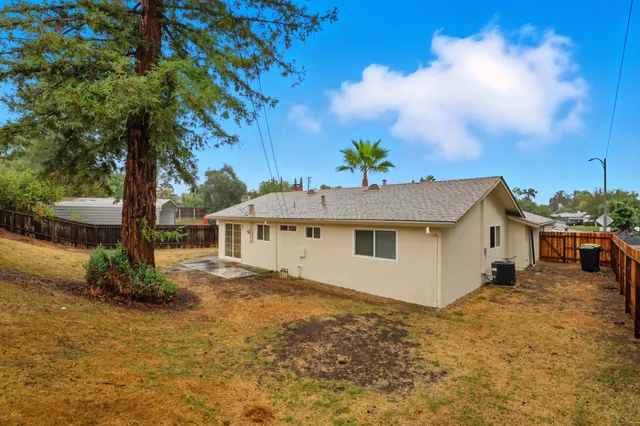 a white house that has a tree in front of it