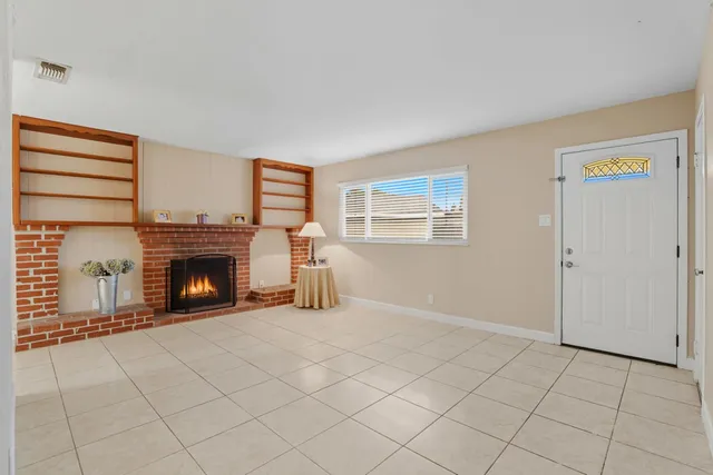 a view of a livingroom with a fireplace and window