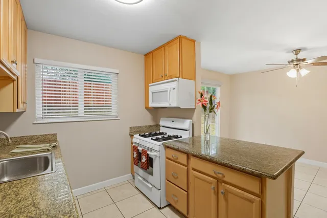 a kitchen with stainless steel appliances granite countertop a stove a sink and a microwave