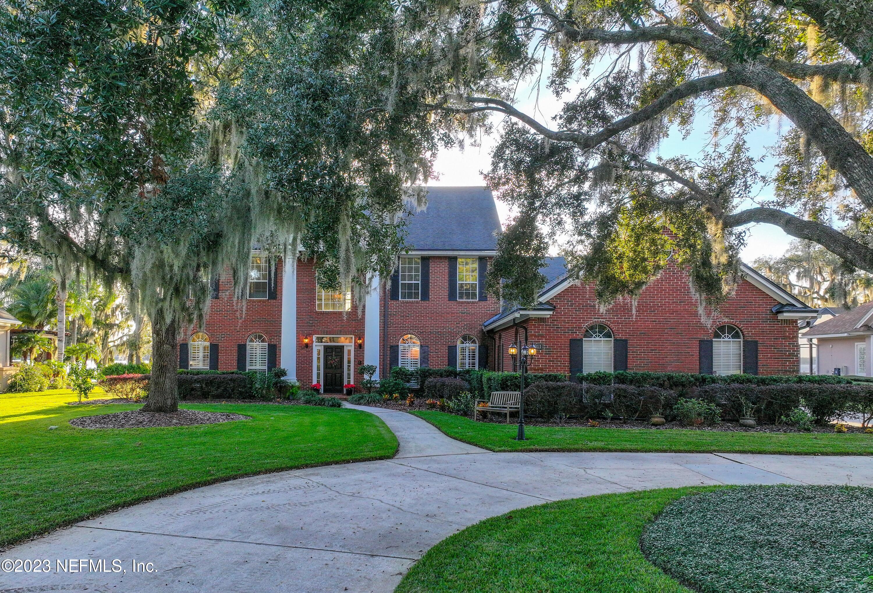 2011 Salt Myrtle Lane Fleming Island, FL 32003 - Photo 113 of 124 a front view of a house with a yard and trees