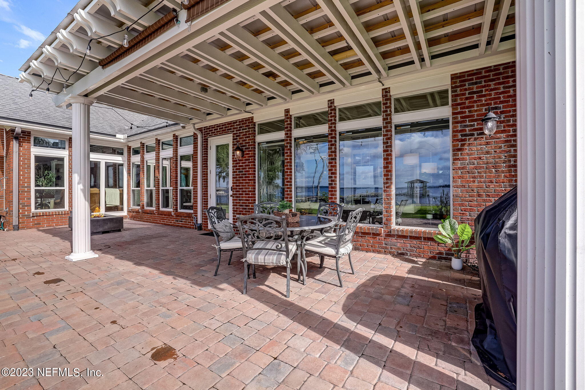 2011 Salt Myrtle Lane Fleming Island, FL 32003 - Photo 69 of 124 a view of a patio with table and chairs potted plants and floor to ceiling window