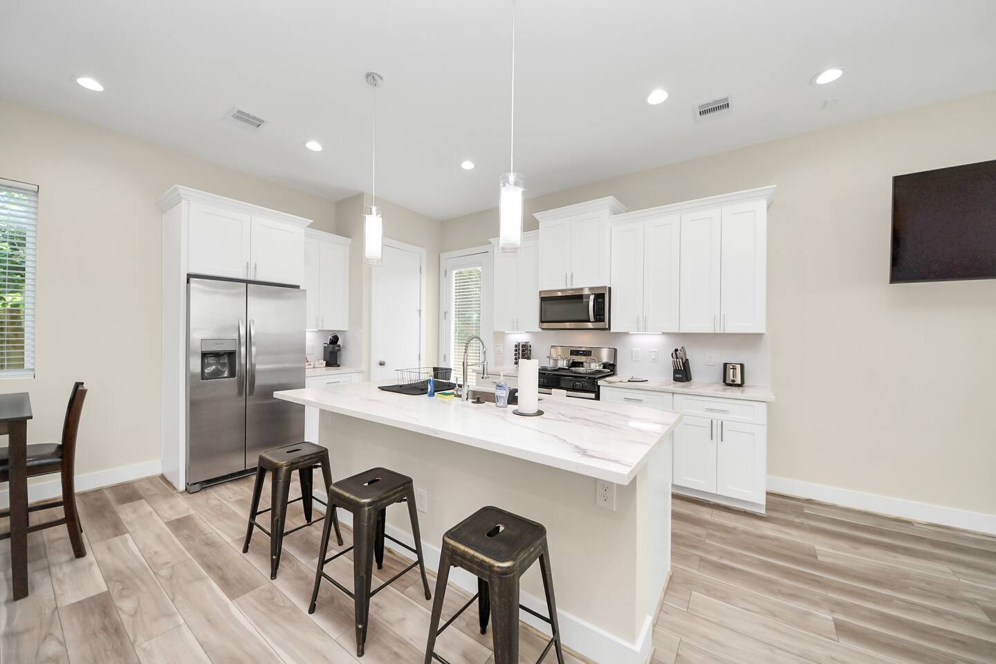 5935 Beall Street, Unit A Houston, TX 77091 - Photo 9 of 50 a kitchen with a sink a microwave a refrigerator and chairs