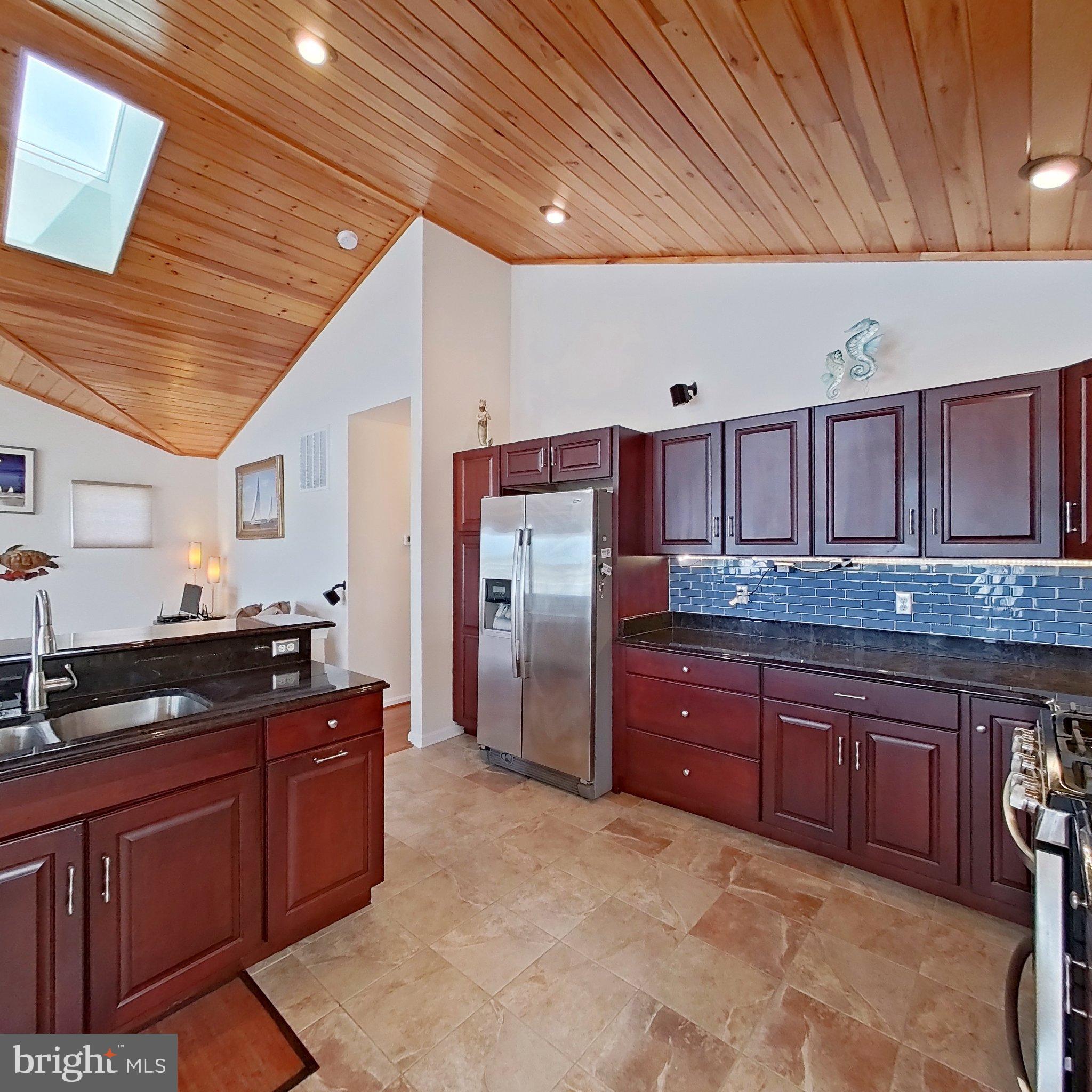 505 South Surf Road Ocean City, MD 21842 - Photo 24 of 49 a kitchen with granite countertop a sink cabinets and stainless steel appliances