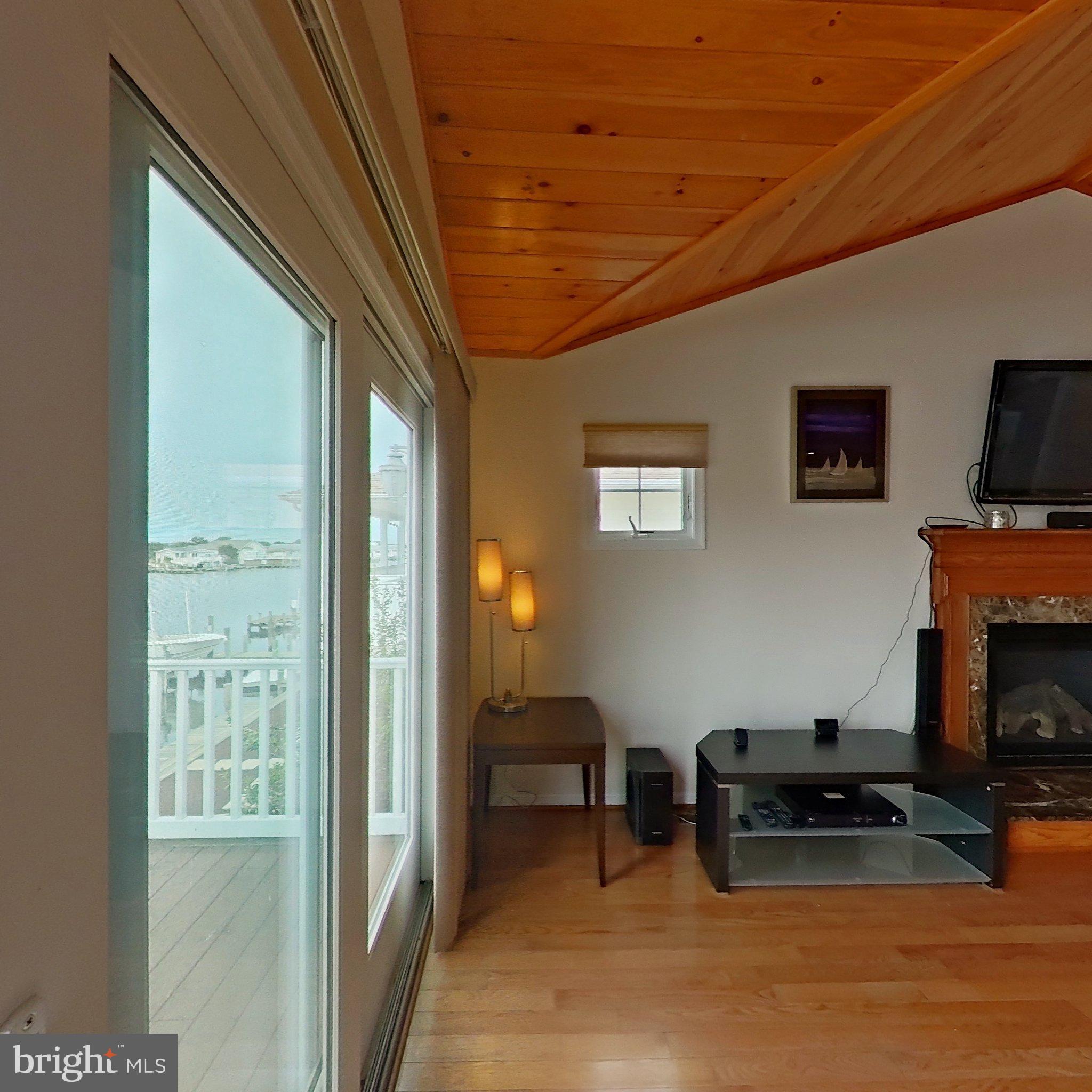 505 South Surf Road Ocean City, MD 21842 - Photo 28 of 49 a living room with furniture a flat screen tv and a fireplace