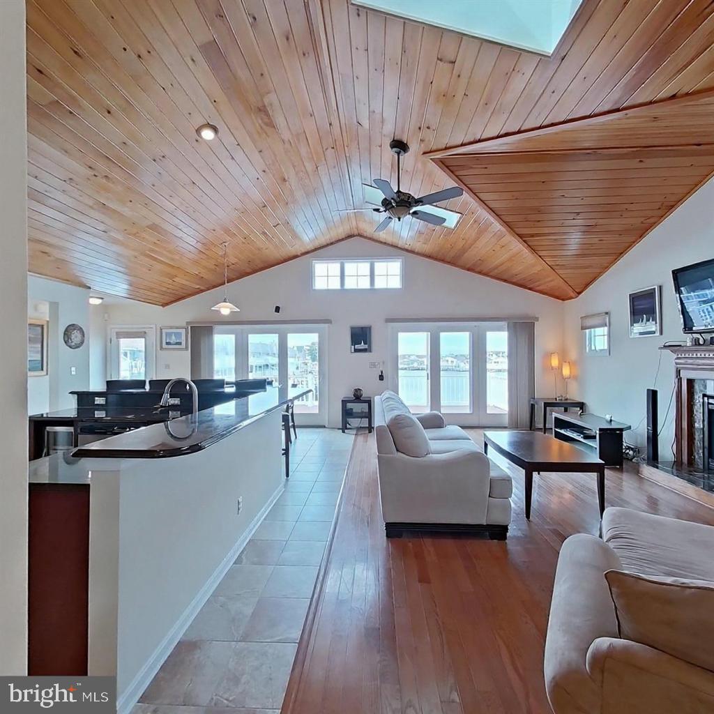 505 South Surf Road Ocean City, MD 21842 - Photo 4 of 49 a living room with furniture a wooden floor and a chandelier