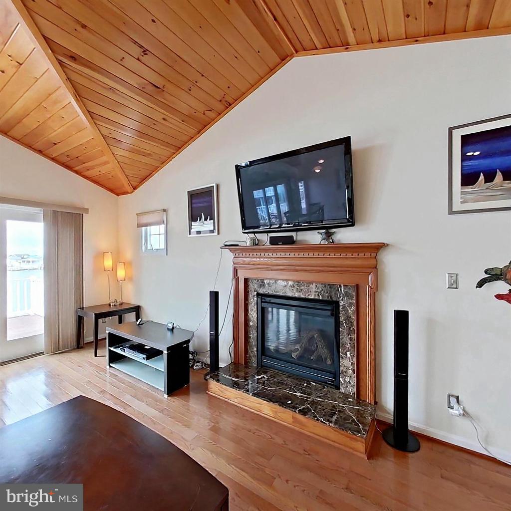 505 South Surf Road Ocean City, MD 21842 - Photo 8 of 49 a living room with furniture a flat screen tv and a fireplace