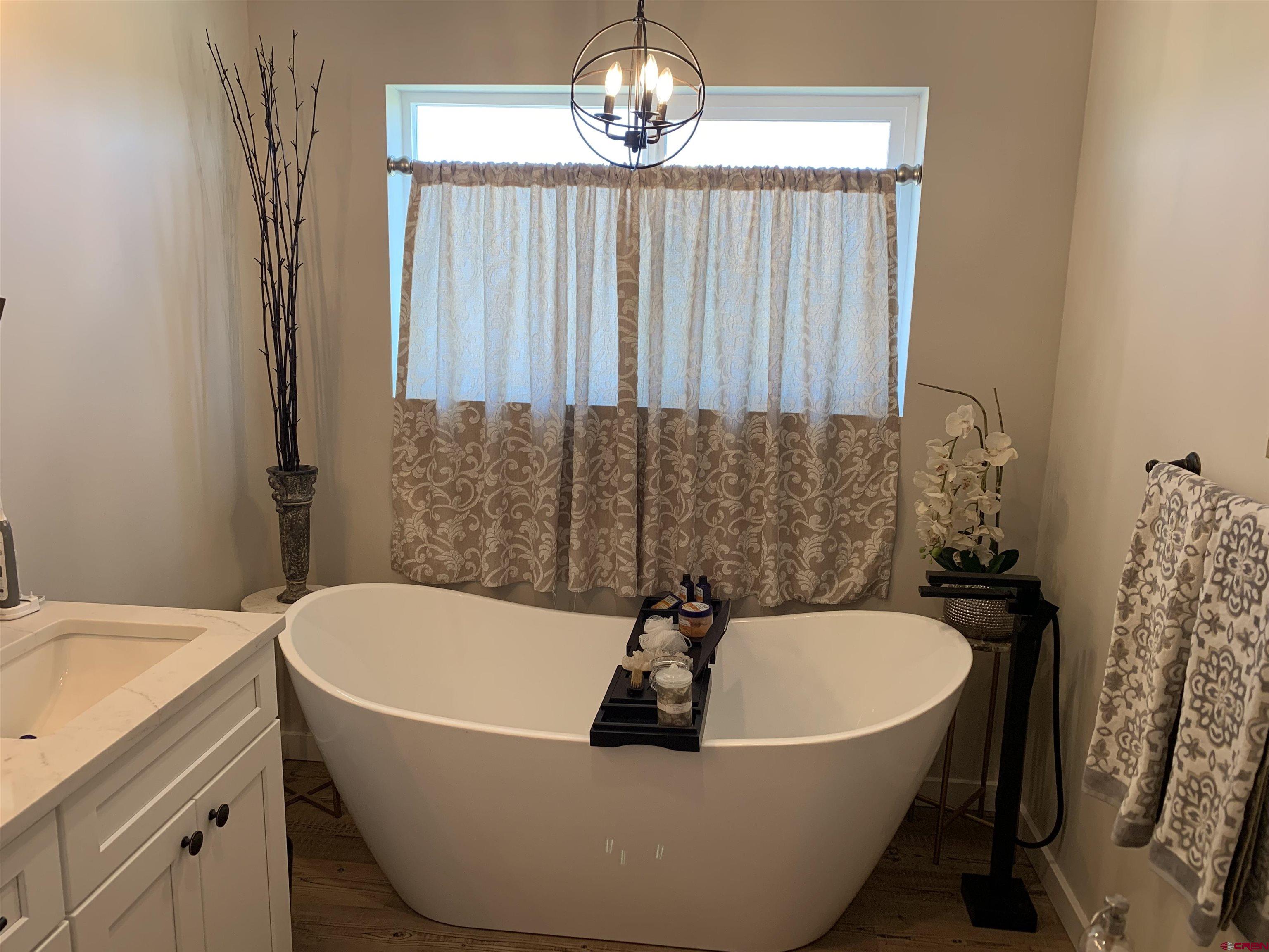 10400 Road 23.5 Cortez, CO 81321 - Photo 16 of 34 a white bath tub sitting in a bathroom