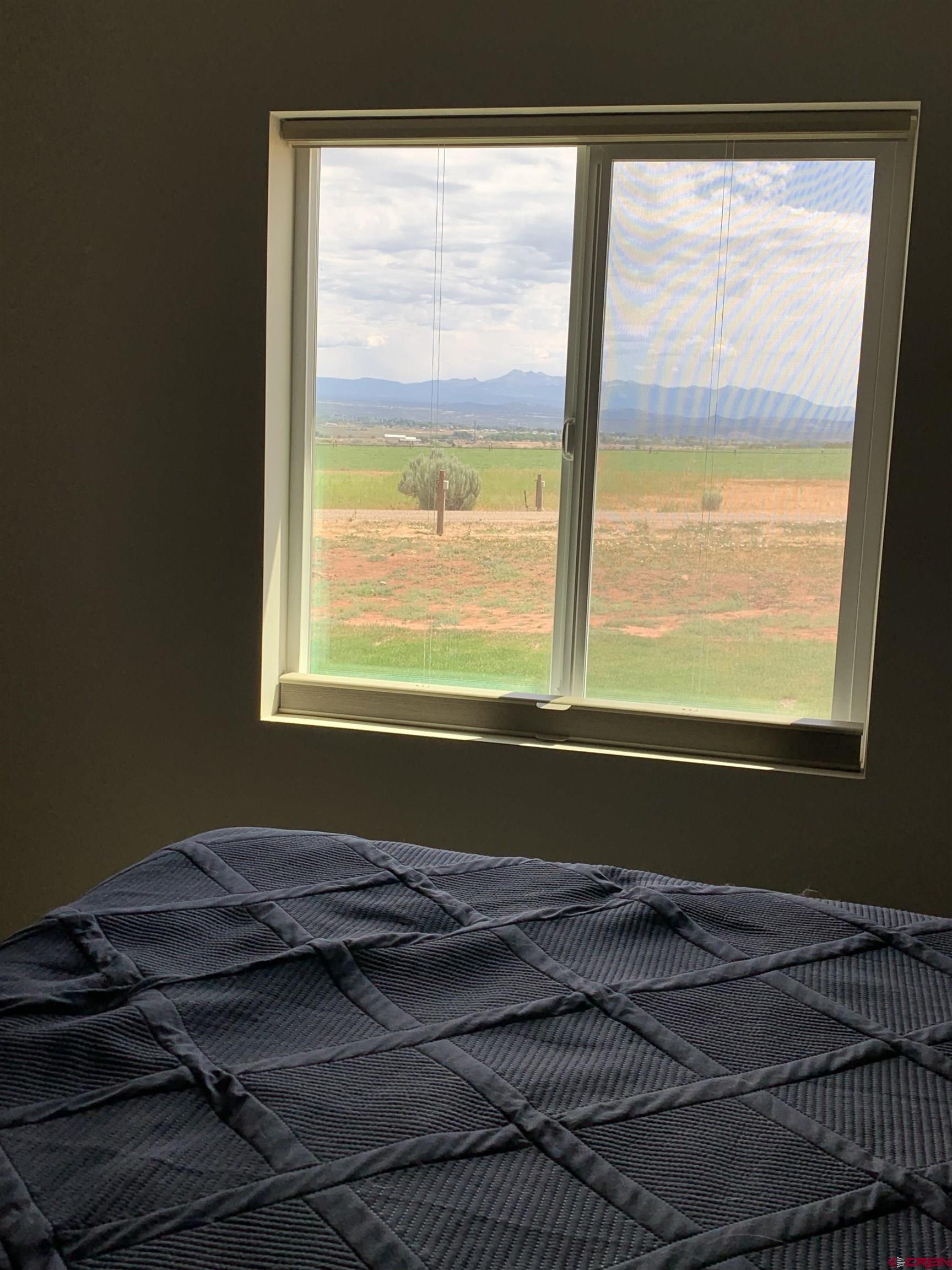 10400 Road 23.5 Cortez, CO 81321 - Photo 21 of 34 a bed sitting in a bedroom next to a window