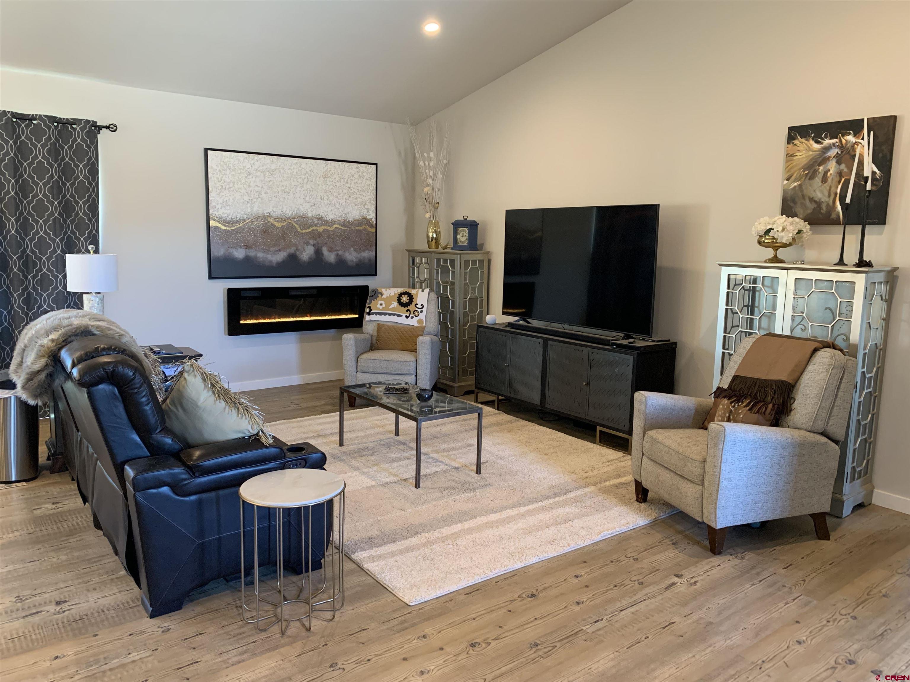 10400 Road 23.5 Cortez, CO 81321 - Photo 4 of 34 a living room with furniture a flat screen tv and paintings on the wall