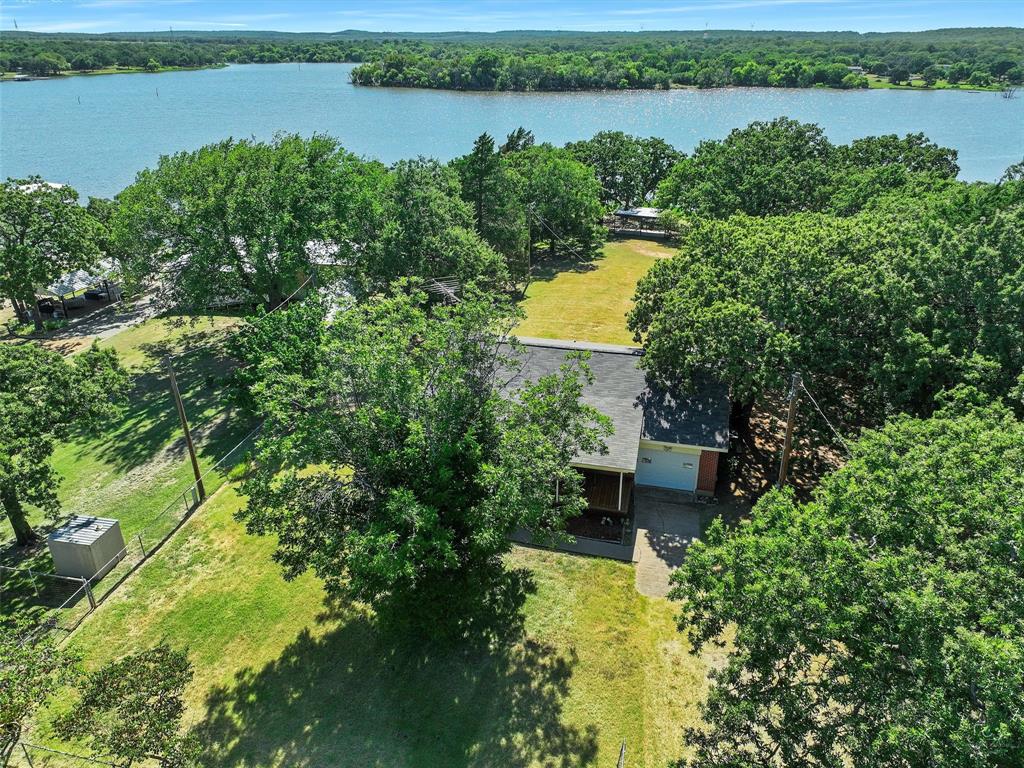 404 Selma Road Bowie, TX 76230 - Photo 4 of 21 a view of a lake with plants and large trees