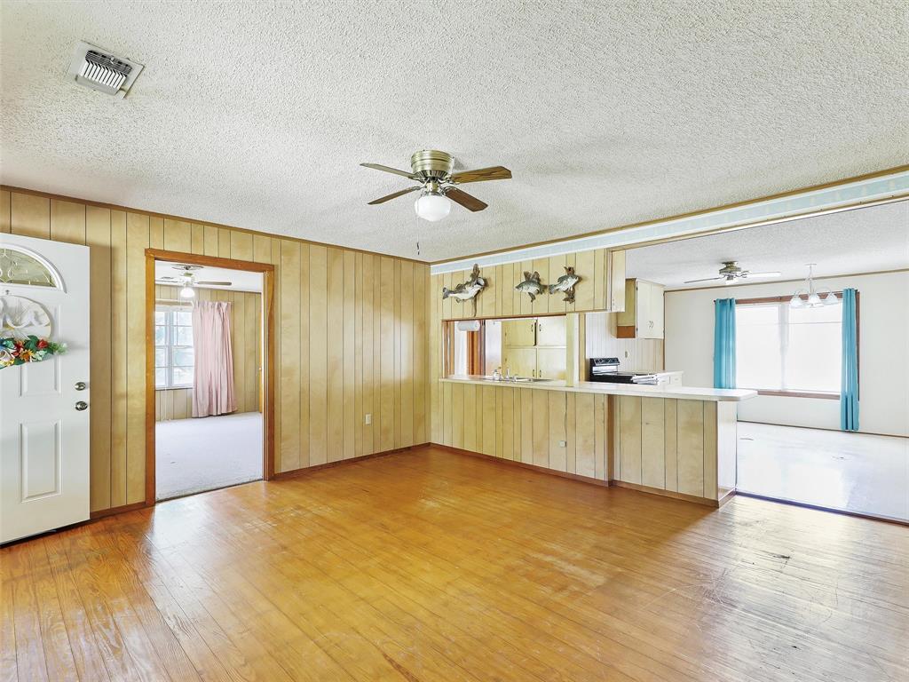 404 Selma Road Bowie, TX 76230 - Photo 9 of 21 a view of an empty room with window and wooden floor
