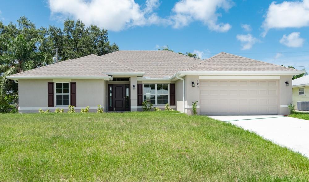 1391 Seahouse Street Sebastian, FL 32958 - Photo 1 of 18 a front view of a house with a garden and yard