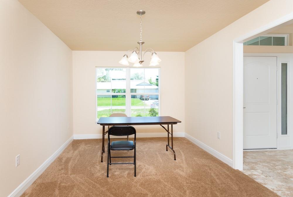 1391 Seahouse Street Sebastian, FL 32958 - Photo 11 of 18 a view of a room with a table chair and chandelier
