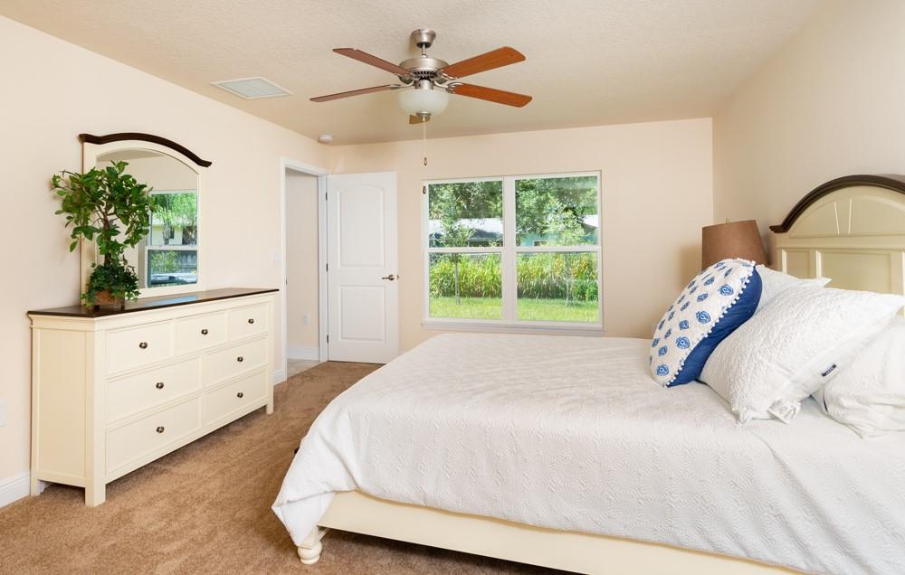 1391 Seahouse Street Sebastian, FL 32958 - Photo 5 of 18 a bedroom with a bed and a potted plant