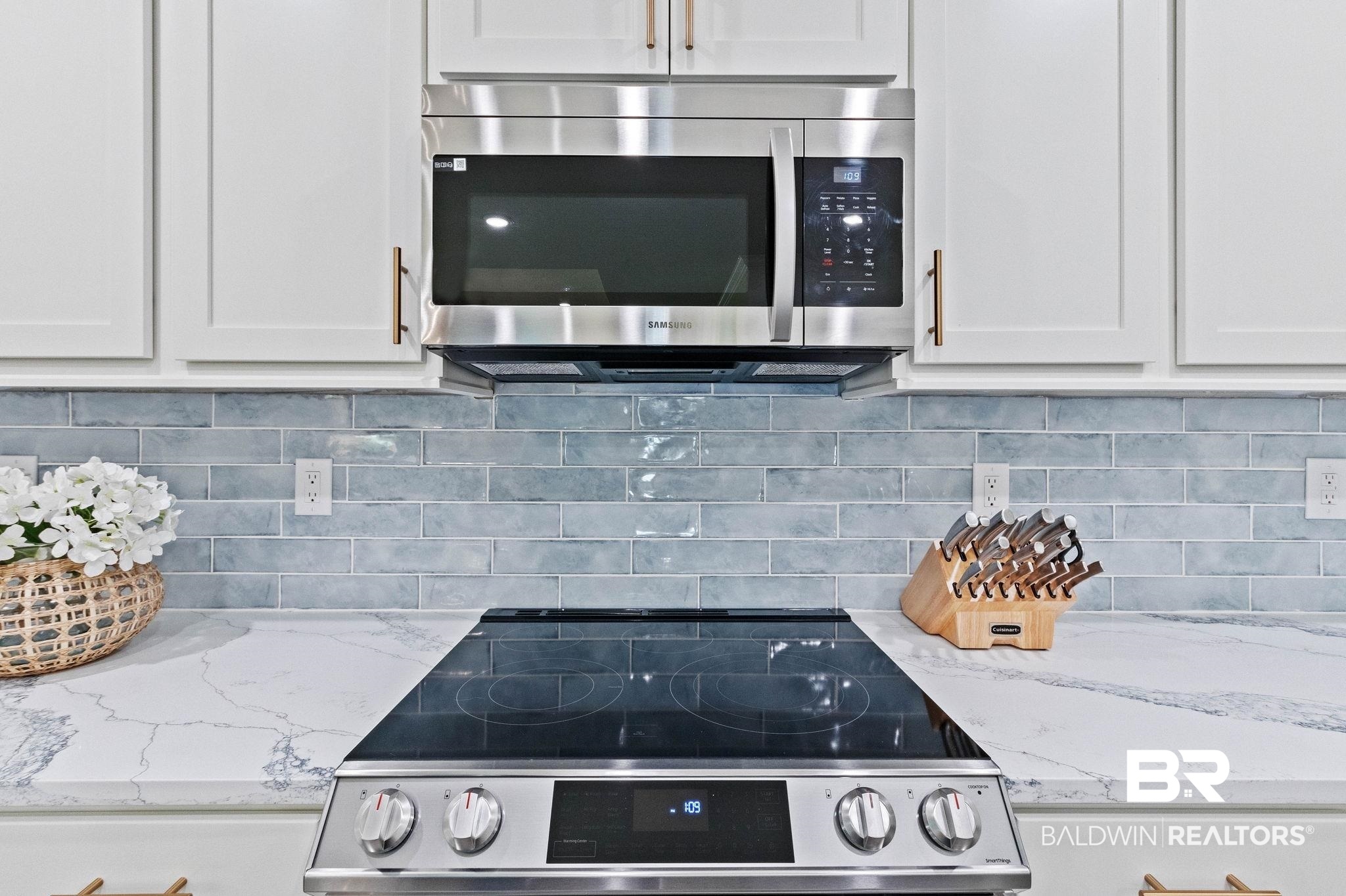 9815 Lakeview Drive Foley, AL 36535 - Photo 26 of 100 Kitchen featuring decorative backsplash, appliances with stainless steel finishes, light stone counters, and white cabinets