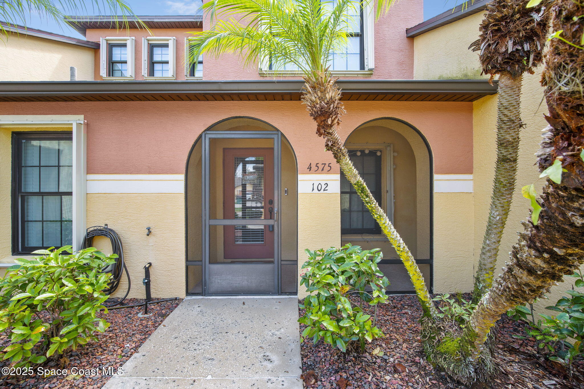 4575 Radiant Way, Unit 102 Melbourne, FL 32901 - Photo 1 of 52 a front view of a house with garden