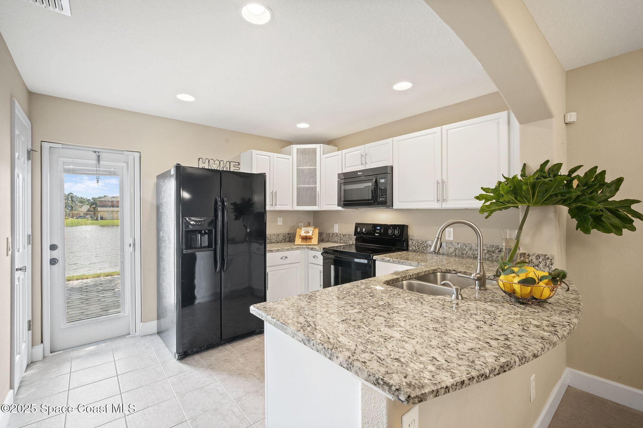 4575 Radiant Way, Unit 102 Melbourne, FL 32901 - Photo 11 of 52 a kitchen with a refrigerator a stove cabinets and living room