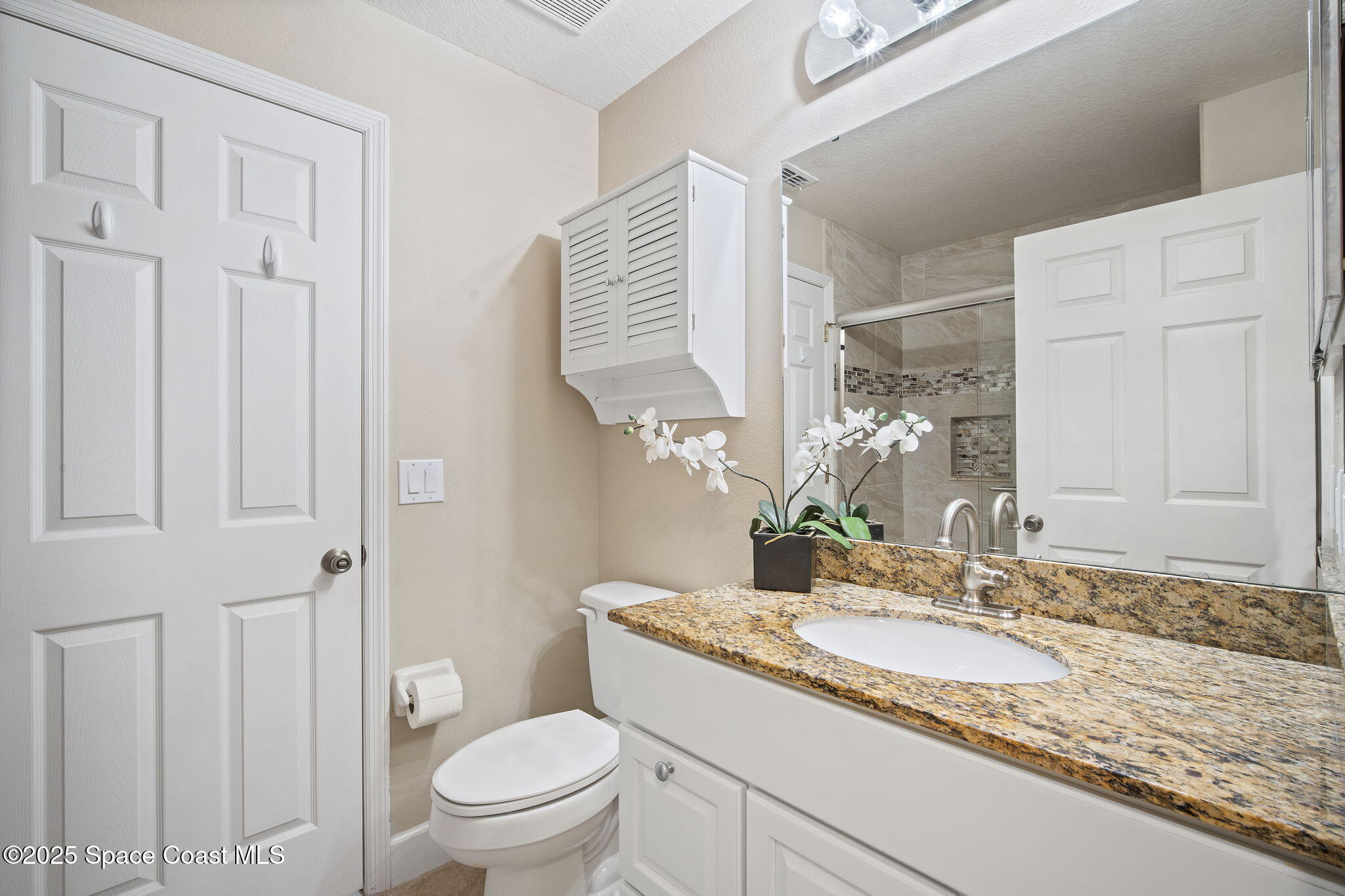 4575 Radiant Way, Unit 102 Melbourne, FL 32901 - Photo 23 of 52 a bathroom with a granite countertop sink toilet and shower