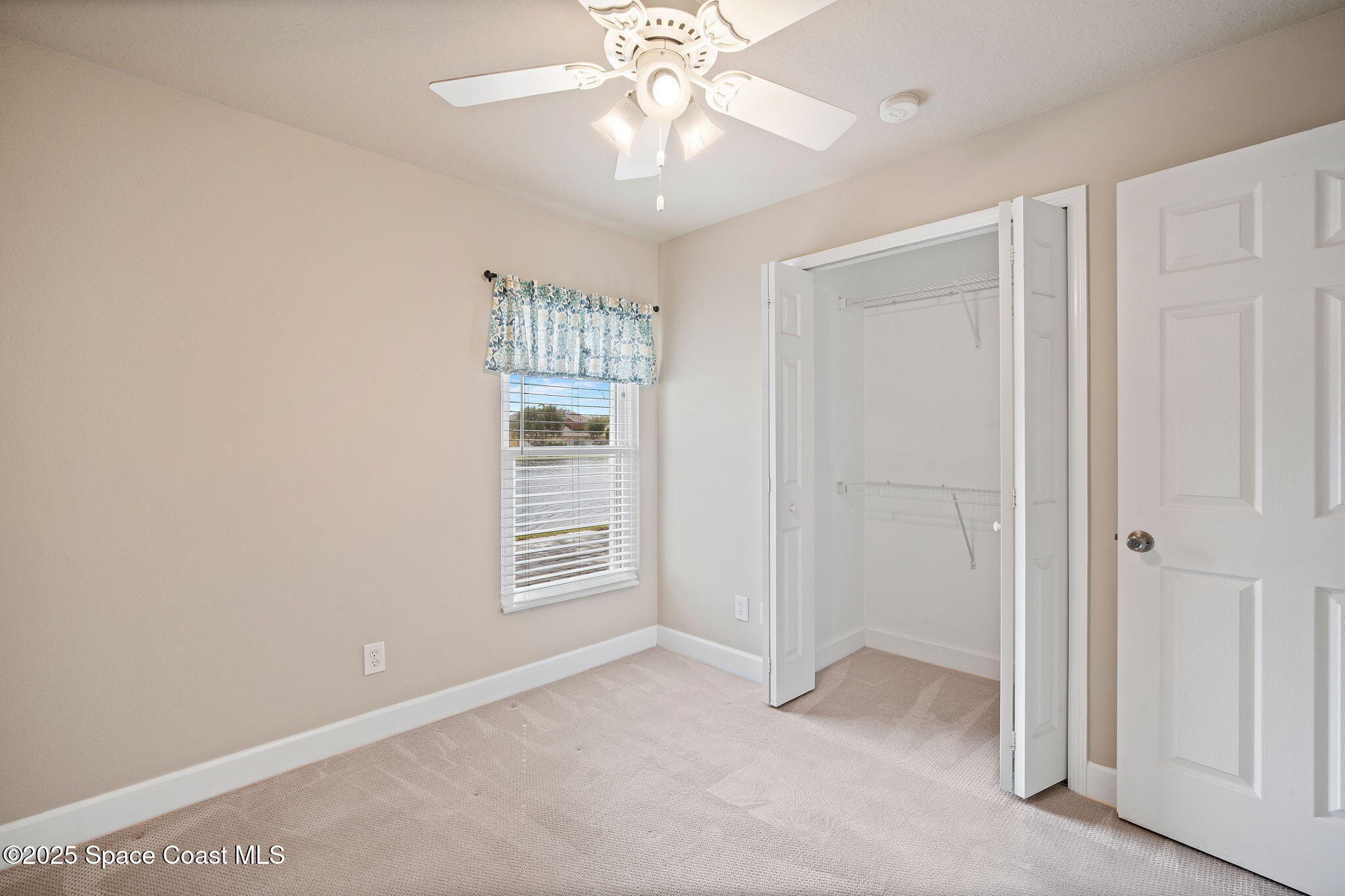 4575 Radiant Way, Unit 102 Melbourne, FL 32901 - Photo 29 of 52 an empty room with windows and ceiling fan