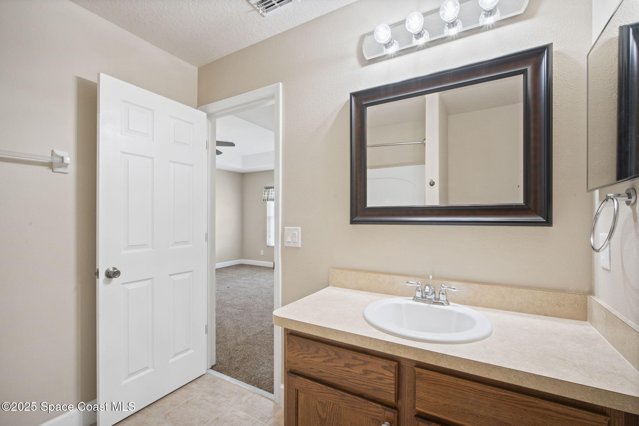 4575 Radiant Way, Unit 102 Melbourne, FL 32901 - Photo 35 of 52 a bathroom with a sink vanity and a mirror