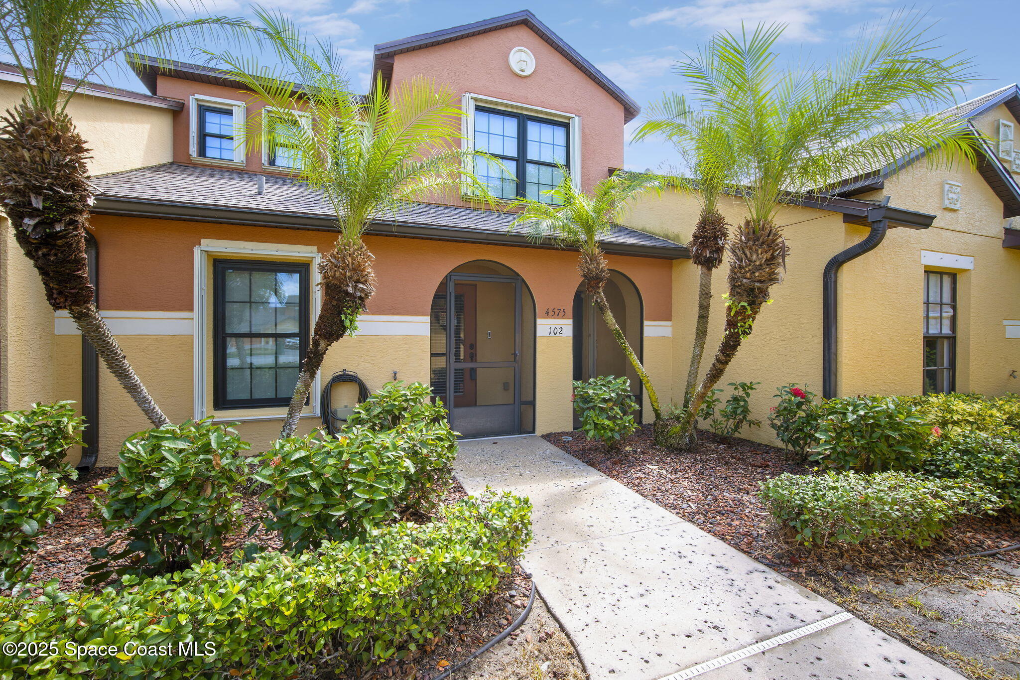 4575 Radiant Way, Unit 102 Melbourne, FL 32901 - Photo 42 of 52 a front view of a house with a garden