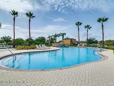 4575 Radiant Way, Unit 102 Melbourne, FL 32901 - Photo 43 of 52 a view of a swimming pool with a lawn chairs