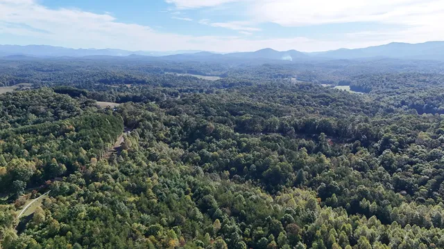 an aerial view of mountains residential house and green space