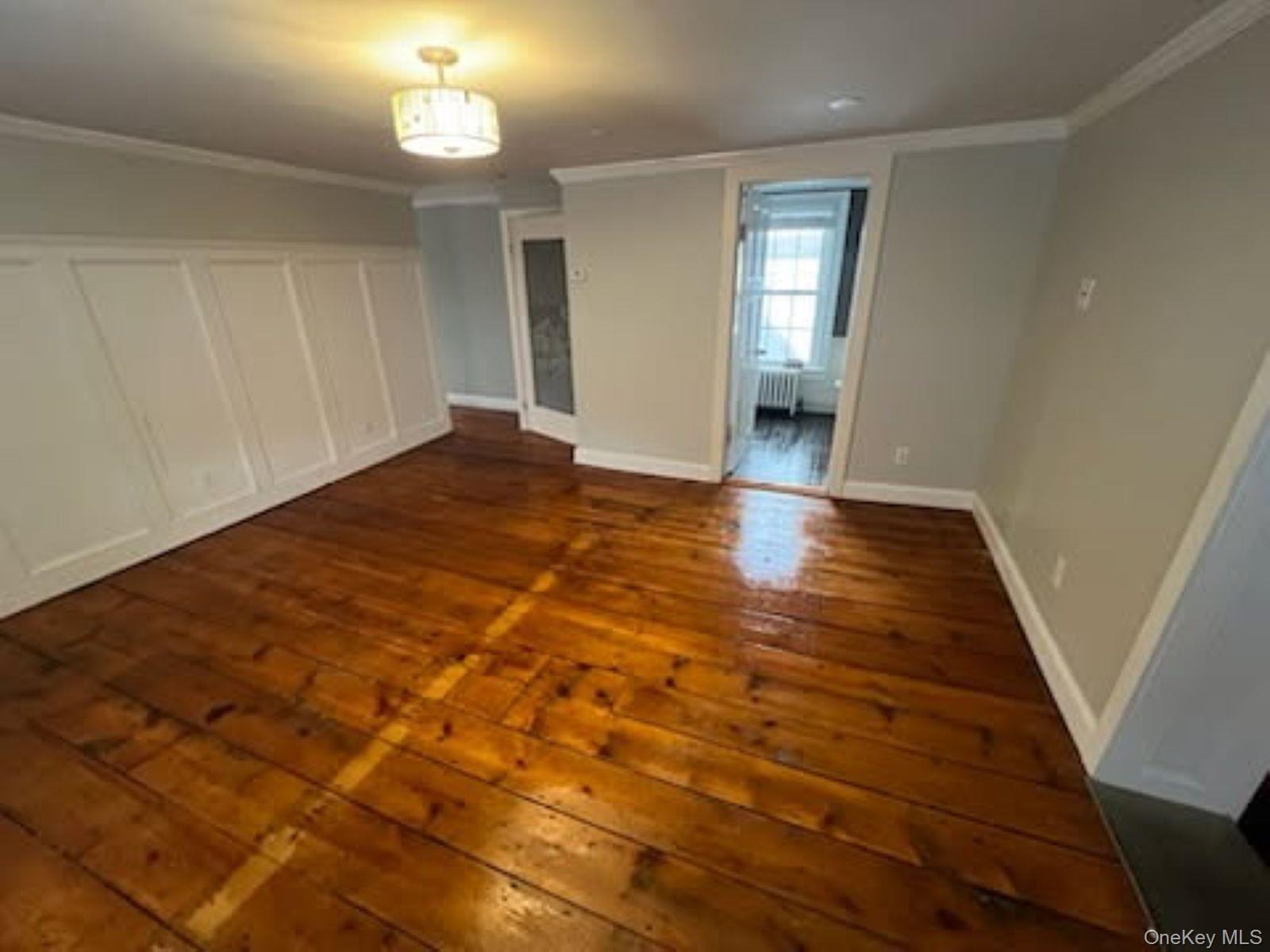 205 Union Street, Unit 2 Poughkeepsie, NY 12601 - Photo 3 of 16 an empty room with wooden floor and windows