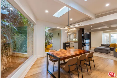 an open kitchen with dining table and wooden floors