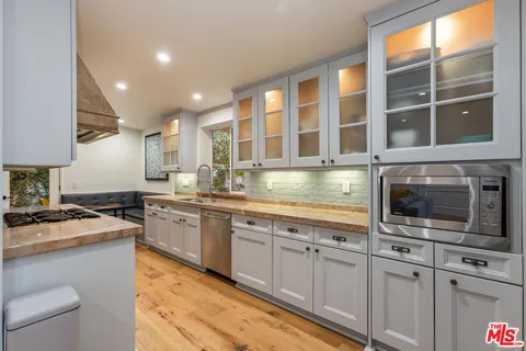 a kitchen with stainless steel appliances granite countertop a stove a sink and a microwave