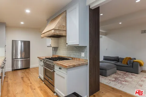 a kitchen with stainless steel appliances granite countertop a stove a refrigerator and a sink