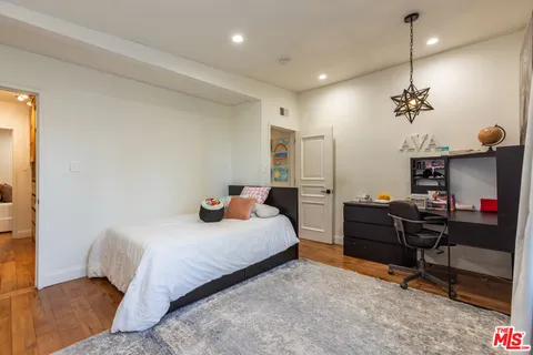 a bedroom with a bed and a refrigerator