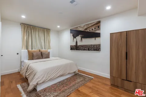 a bedroom with a bed and a painting on the wall